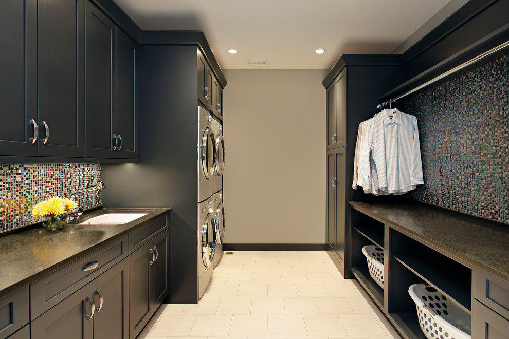 Inspiration for a transitional laundry room in Chicago with a stacked washer and dryer, beige floor and grey benchtop.