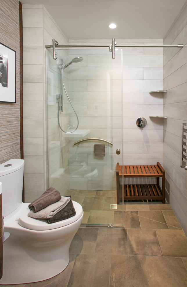 This is an example of a small contemporary bathroom in Philadelphia with a curbless shower, a two-piece toilet, gray tile, ceramic tile, beige walls, ceramic floors, a wall-mount sink, multi-coloured floor and a sliding shower screen.