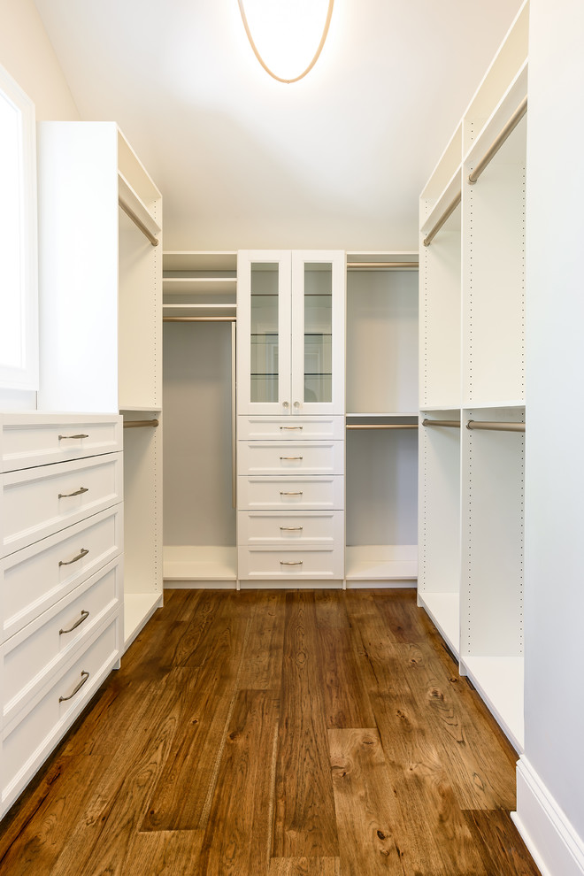 Mid-sized beach style gender-neutral walk-in wardrobe in Jacksonville with shaker cabinets, white cabinets and medium hardwood floors.