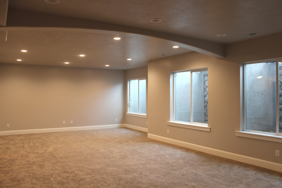 Photo of a large traditional fully buried basement in Salt Lake City with grey walls and carpet.