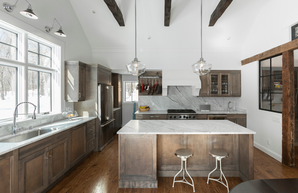 Large country l-shaped eat-in kitchen in New York with an undermount sink, light wood cabinets, grey splashback, stainless steel appliances, dark hardwood floors, with island, shaker cabinets, marble benchtops, stone slab splashback and brown floor.