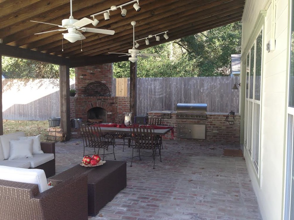 Design ideas for a mid-sized country backyard patio in New Orleans with an outdoor kitchen, brick pavers and an awning.