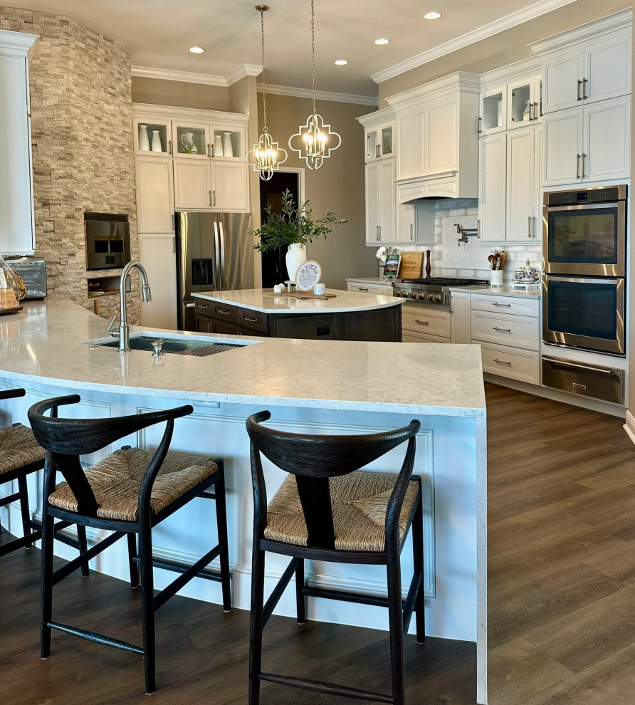 Kitchen - large transitional kitchen idea in Orlando with recessed-panel cabinets, white cabinets, quartz countertops, white backsplash, porcelain backsplash, stainless steel appliances, two islands and white countertops