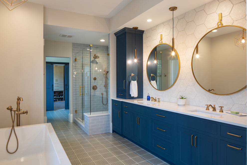Пример оригинального дизайна: главная ванная комната среднего размера в классическом стиле с синими фасадами, отдельно стоящей ванной, душем в нише, унитазом-моноблоком, белой плиткой, терракотовой плиткой, белыми стенами, полом из керамогранита, врезной раковиной, столешницей из искусственного кварца, серым полом, белой столешницей, сиденьем для душа, тумбой под две раковины и напольной тумбой