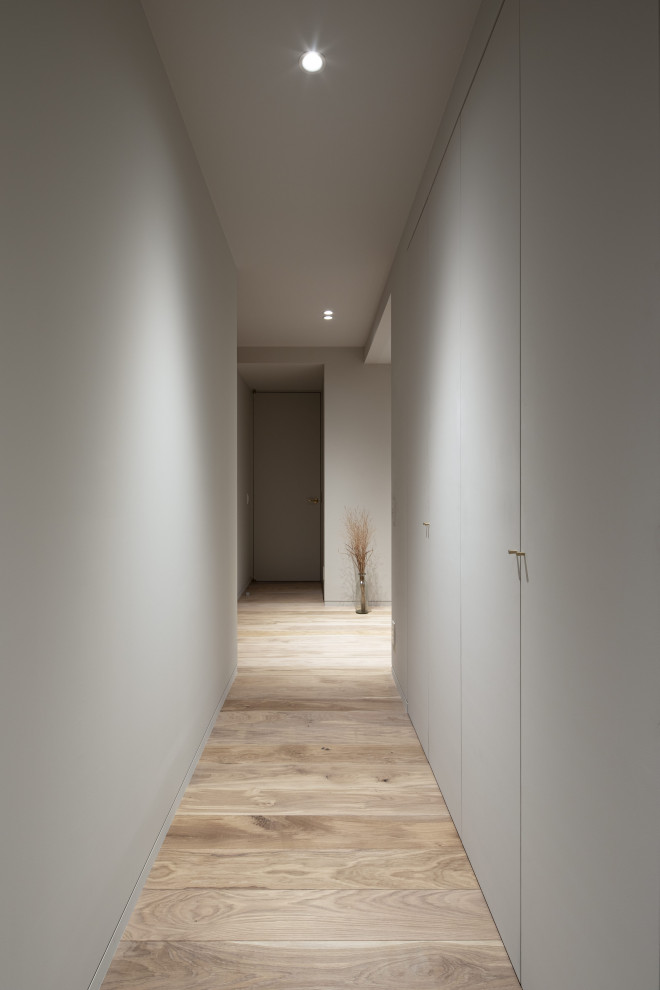 Idée de décoration pour un couloir minimaliste de taille moyenne avec un mur blanc, parquet clair, un sol marron, un plafond en lambris de bois et du lambris de bois.