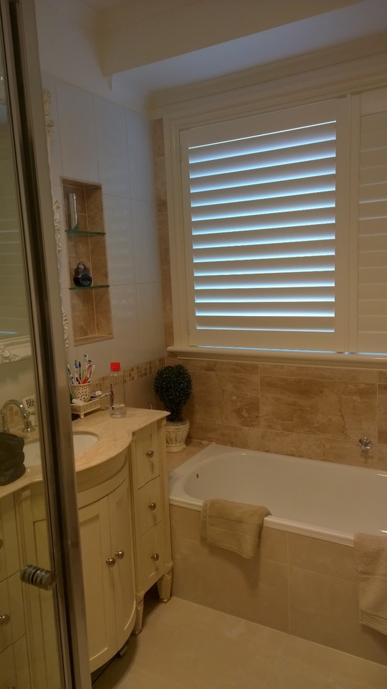 Design ideas for a mid-sized mediterranean bathroom in Melbourne with an undermount sink, furniture-like cabinets, beige cabinets, a corner tub, a corner shower, multi-coloured tile, porcelain tile, multi-coloured walls and porcelain floors.