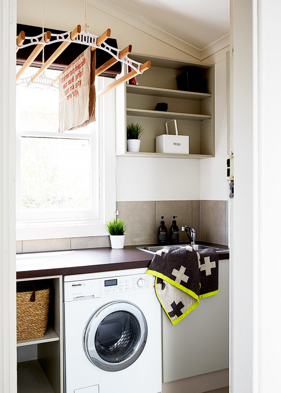 Small modern dedicated laundry room in Melbourne with a single-bowl sink, grey cabinets, laminate benchtops, white walls and ceramic floors.