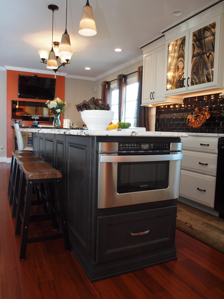 Eat-in kitchen - large transitional medium tone wood floor eat-in kitchen idea in Philadelphia with an undermount sink, raised-panel cabinets, white cabinets, granite countertops, black backsplash, ceramic backsplash, stainless steel appliances and an island