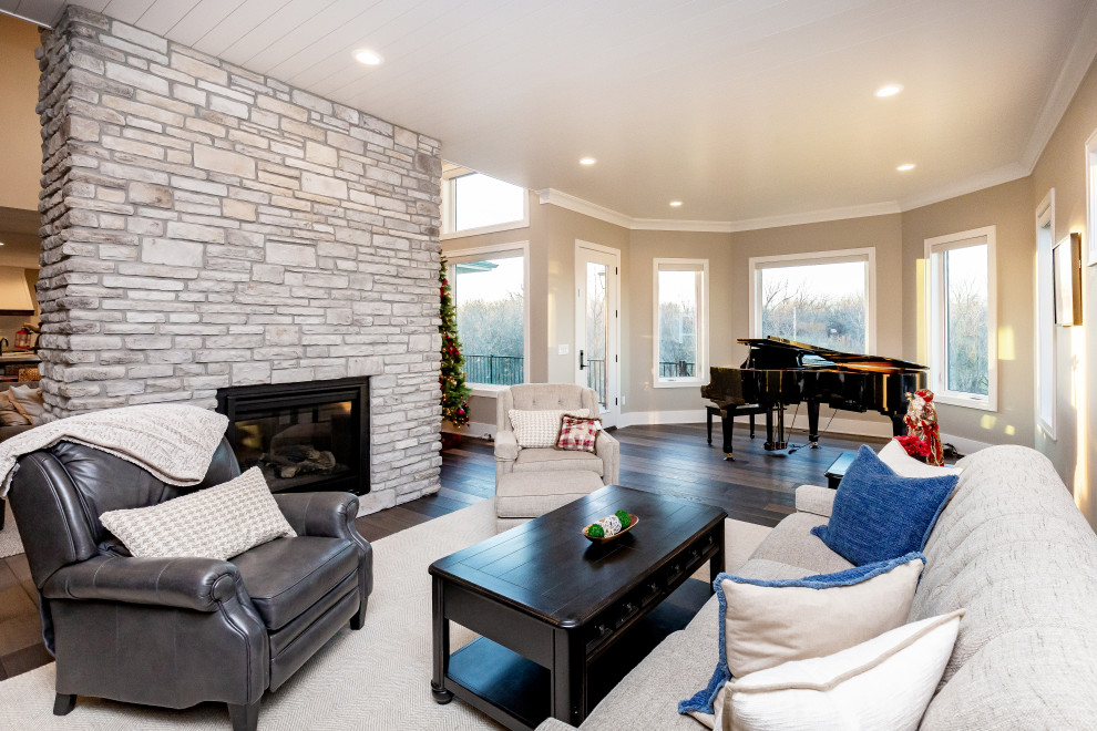 Photo of a large transitional open concept family room in Other with a music area, grey walls, vinyl floors, a standard fireplace, a stone fireplace surround, no tv and brown floor.
