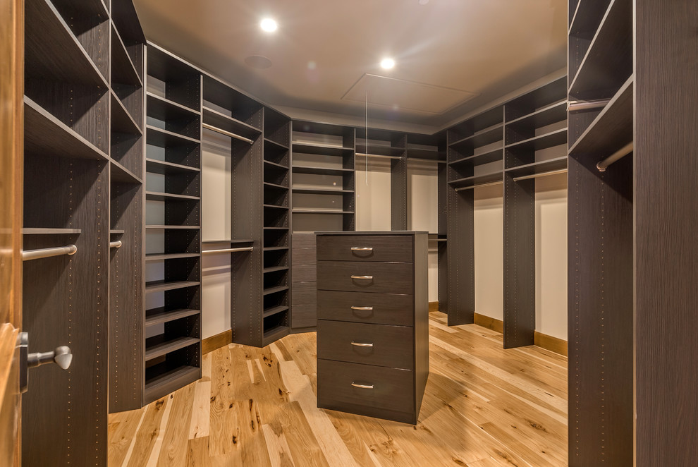Huge tuscan gender-neutral light wood floor walk-in closet photo in San Francisco with flat-panel cabinets and dark wood cabinets