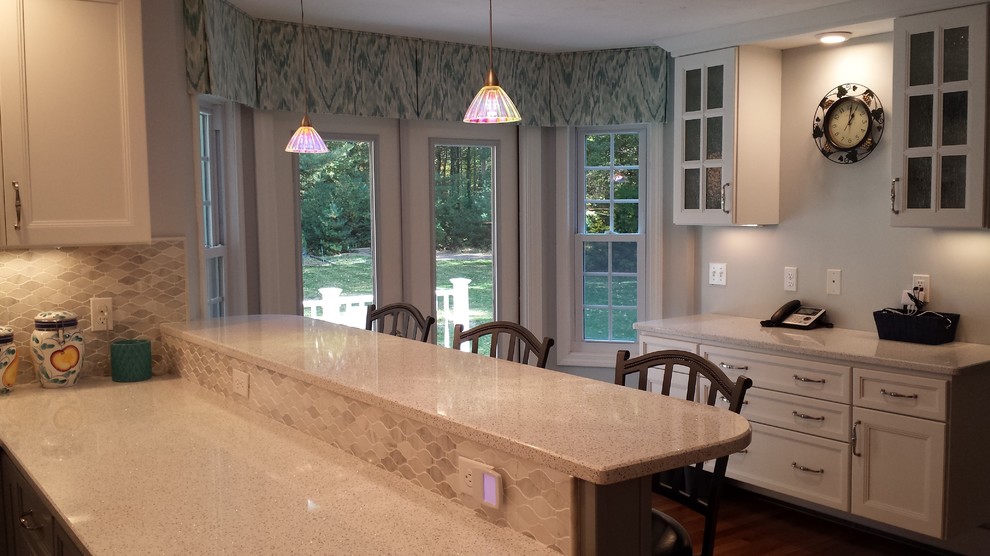 Inspiration for a transitional u-shaped medium tone wood floor kitchen remodel in Boston with white cabinets, quartz countertops, multicolored backsplash and a peninsula