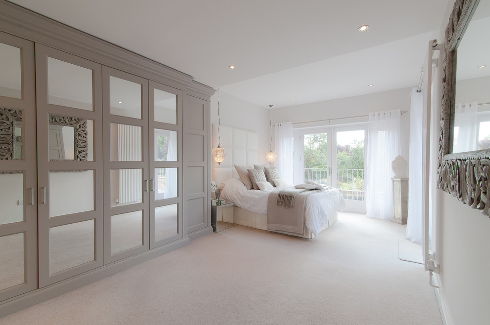 Design ideas for a transitional bedroom in Surrey with white walls and carpet.