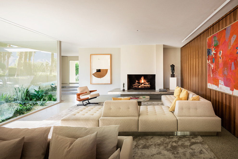 Midcentury living room in New York with beige walls, a standard fireplace and grey floor.