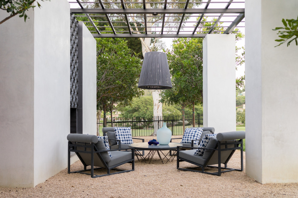Inspiration for a mediterranean patio in San Diego with with fireplace, gravel and a pergola.