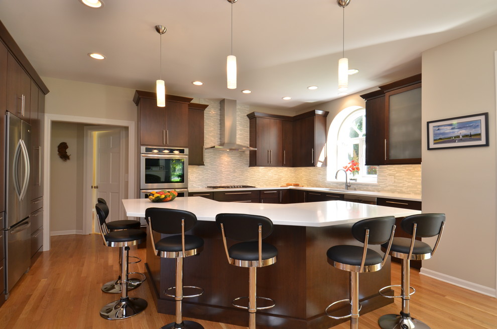 Inspiration for a mid-sized transitional l-shaped light wood floor eat-in kitchen remodel in Chicago with an undermount sink, flat-panel cabinets, dark wood cabinets, quartzite countertops, multicolored backsplash, matchstick tile backsplash, stainless steel appliances and an island