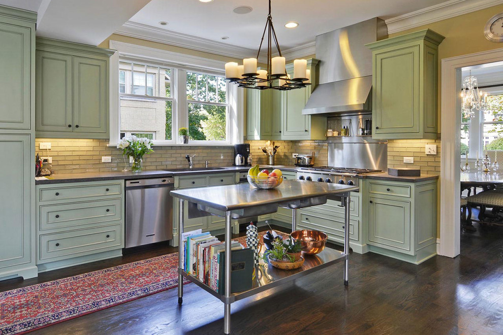 Eat-in kitchen - mid-sized transitional l-shaped dark wood floor and brown floor eat-in kitchen idea in Chicago with an undermount sink, recessed-panel cabinets, green cabinets, soapstone countertops, beige backsplash, brick backsplash, stainless steel appliances and an island
