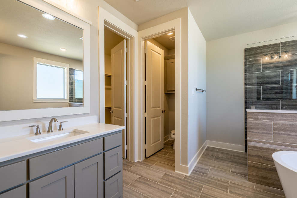 This is an example of a large traditional master bathroom in Dallas with shaker cabinets, a freestanding tub, an open shower, beige tile, porcelain tile, beige walls, porcelain floors, an undermount sink, engineered quartz benchtops, multi-coloured floor, an open shower, white benchtops, a shower seat, a double vanity and a built-in vanity.