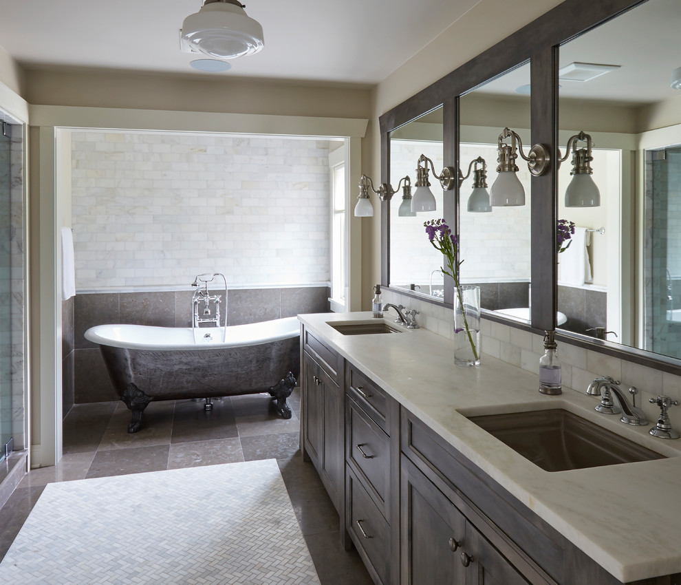 Photo of a large transitional master wet room bathroom in Chicago with flat-panel cabinets, grey cabinets, a claw-foot tub, white tile, marble, beige walls, brick floors, an undermount sink, multi-coloured floor, a hinged shower door and white benchtops.