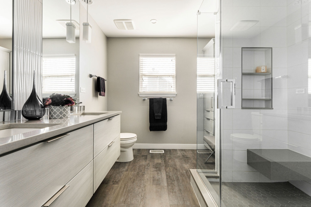Design ideas for a mid-sized contemporary master bathroom in Chicago with grey cabinets, an alcove shower, a two-piece toilet, white tile, porcelain tile, grey walls, vinyl floors, an undermount sink, engineered quartz benchtops, brown floor, a hinged shower door, grey benchtops, a shower seat, a double vanity and a floating vanity.