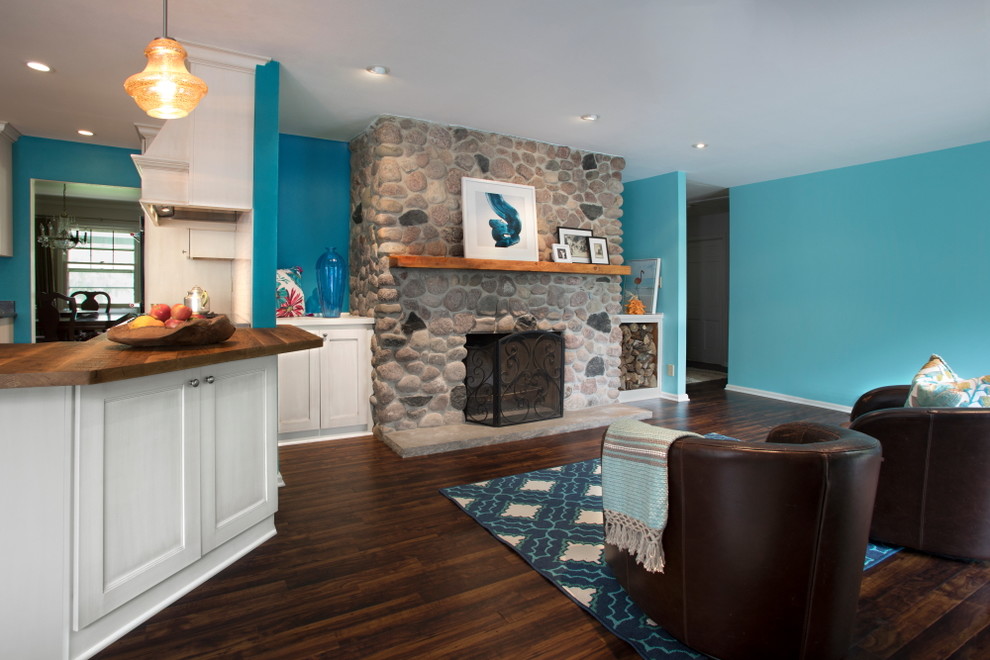 Mid-sized beach style open concept family room in Milwaukee with blue walls, vinyl floors, a standard fireplace, a stone fireplace surround and brown floor.