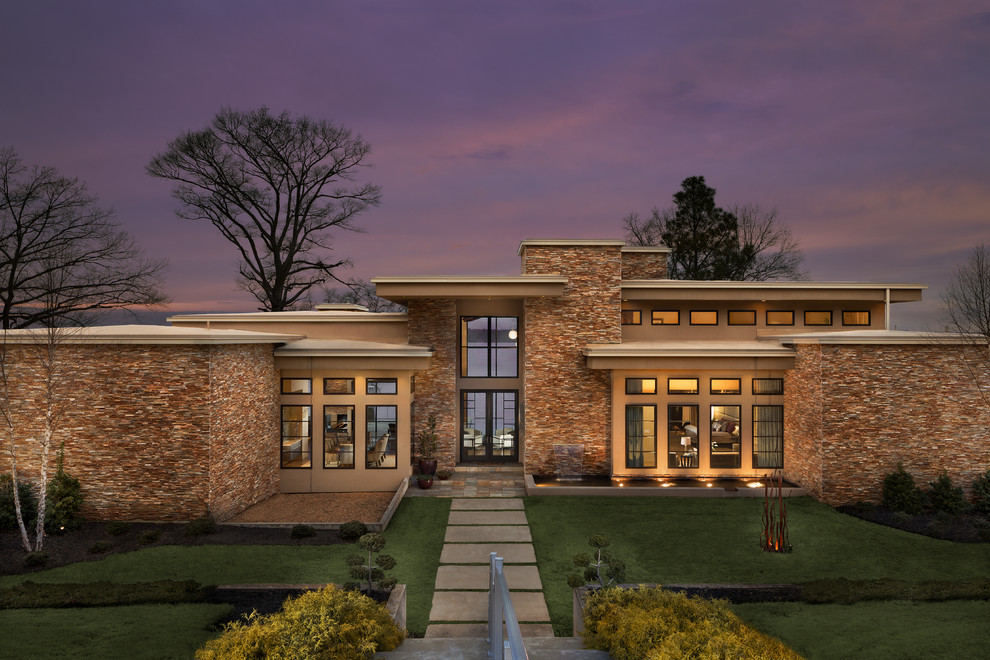 Photo of a contemporary beige exterior in Other with stone veneer and a flat roof.