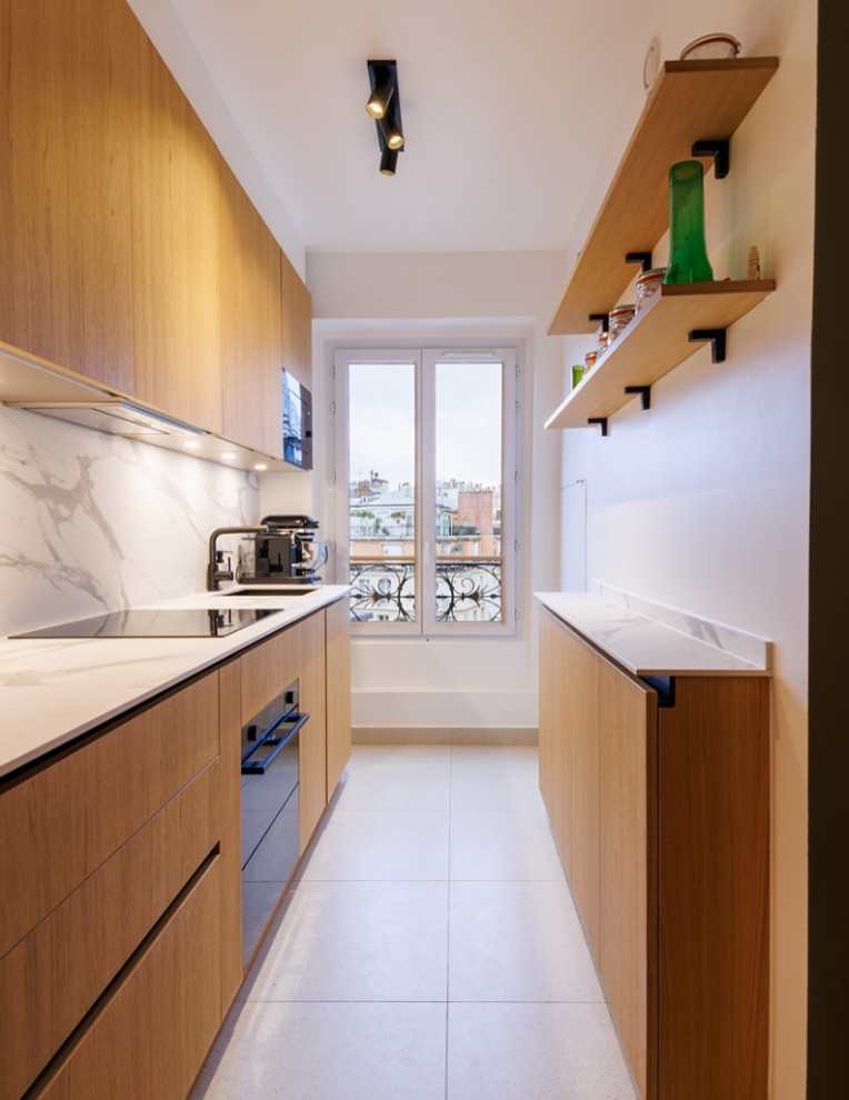 Design ideas for a mid-sized modern galley open plan kitchen in Paris with an undermount sink, recessed-panel cabinets, medium wood cabinets, solid surface benchtops, white splashback, marble splashback, panelled appliances, ceramic floors, no island, beige floor and white benchtop.