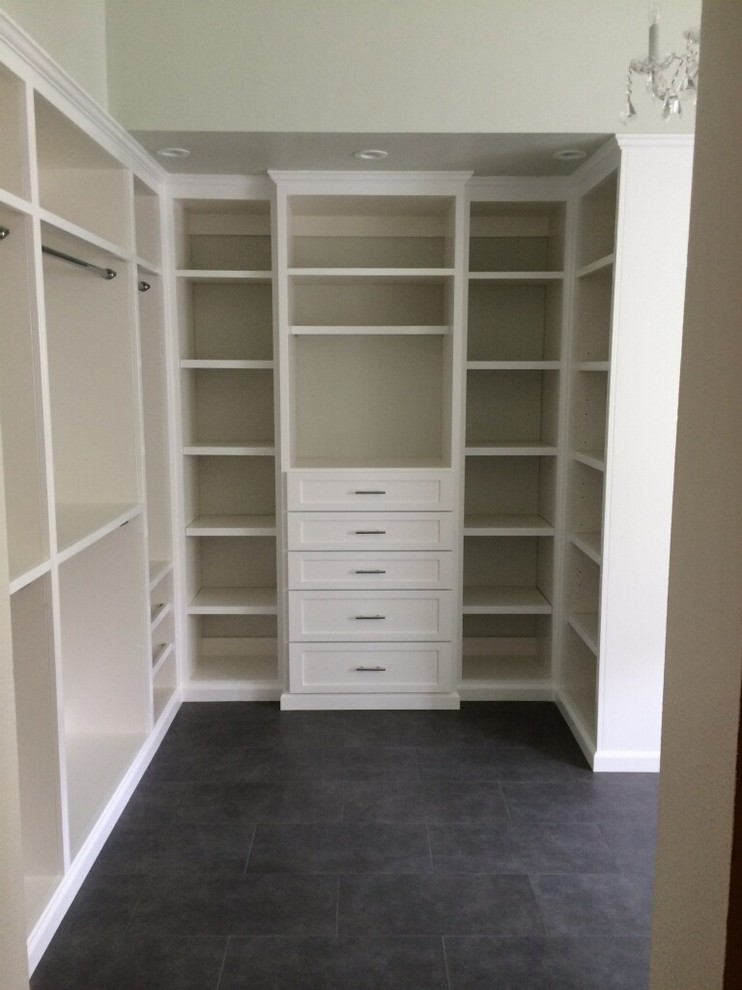 Photo of a large modern gender neutral walk-in wardrobe in Orange County with white cabinets and ceramic flooring.