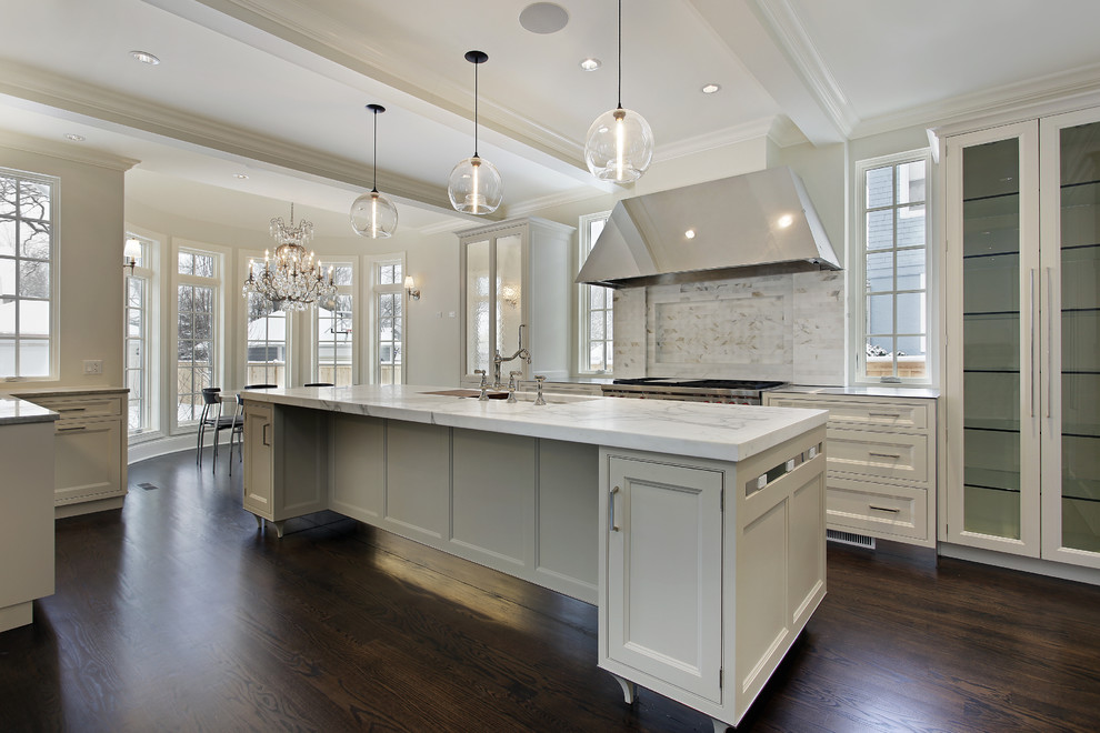 Expansive transitional u-shaped open plan kitchen in Atlanta with an undermount sink, beaded inset cabinets, white cabinets, marble benchtops, white splashback, stone tile splashback, stainless steel appliances, dark hardwood floors, with island, brown floor, white benchtop and coffered.