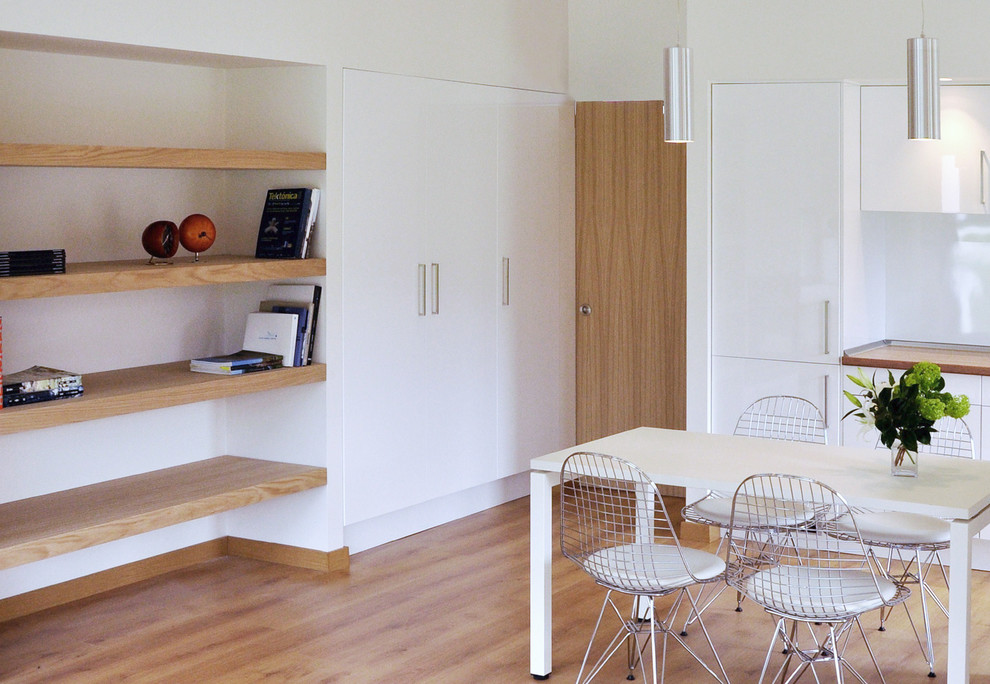 Foto de comedor tradicional renovado pequeño abierto sin chimenea con paredes blancas y suelo de madera en tonos medios