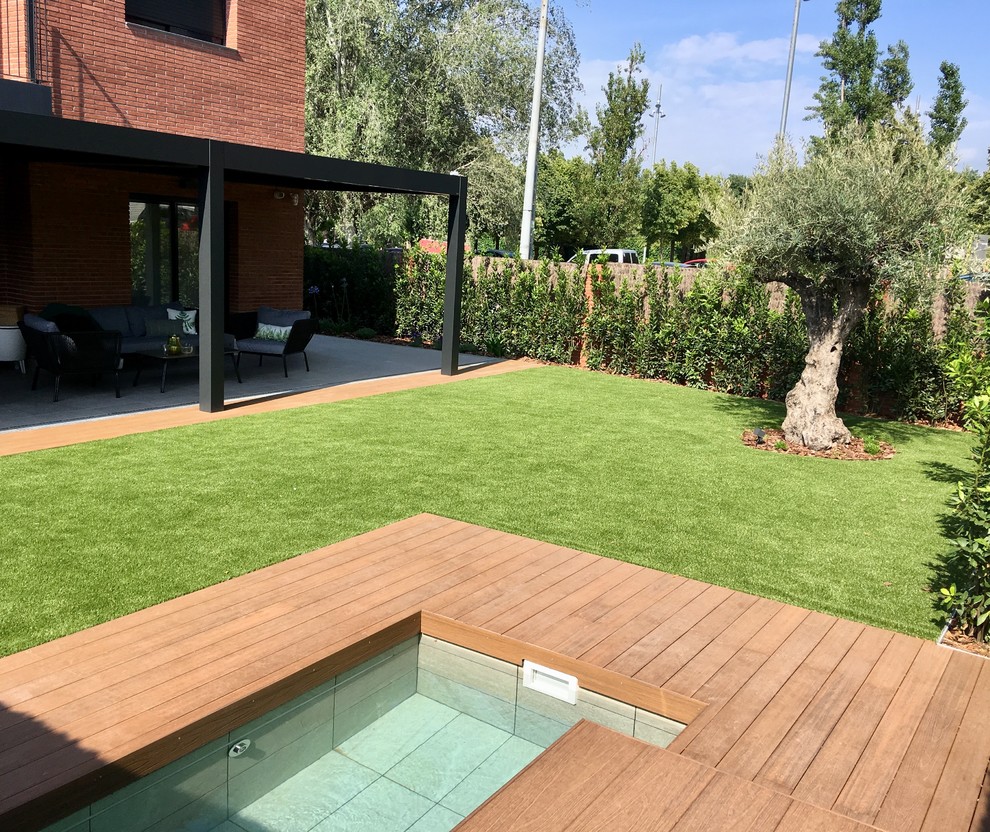 Design ideas for a mid-sized modern front yard full sun driveway in Barcelona with decking.