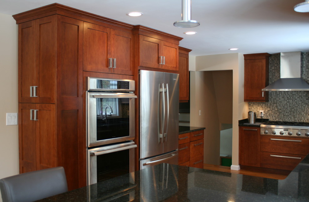 Exempel på ett stort klassiskt kök, med en undermonterad diskho, skåp i shakerstil, skåp i mellenmörkt trä, granitbänkskiva, beige stänkskydd, stänkskydd i glaskakel, rostfria vitvaror, mellanmörkt trägolv och en halv köksö