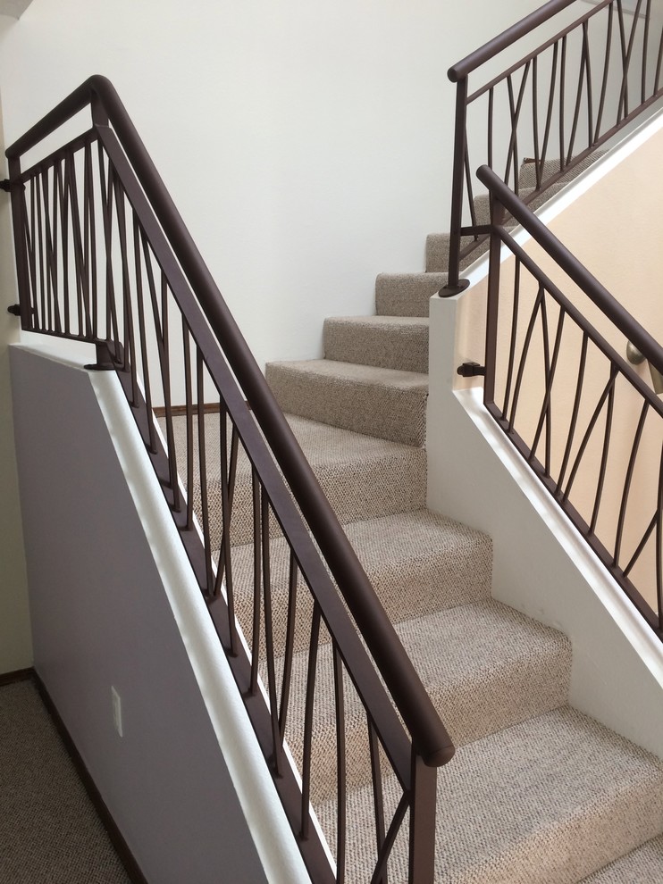Пример оригинального дизайна: угловая лестница в стиле модернизм с металлическими ступенями, ковровыми подступенками и металлическими перилами