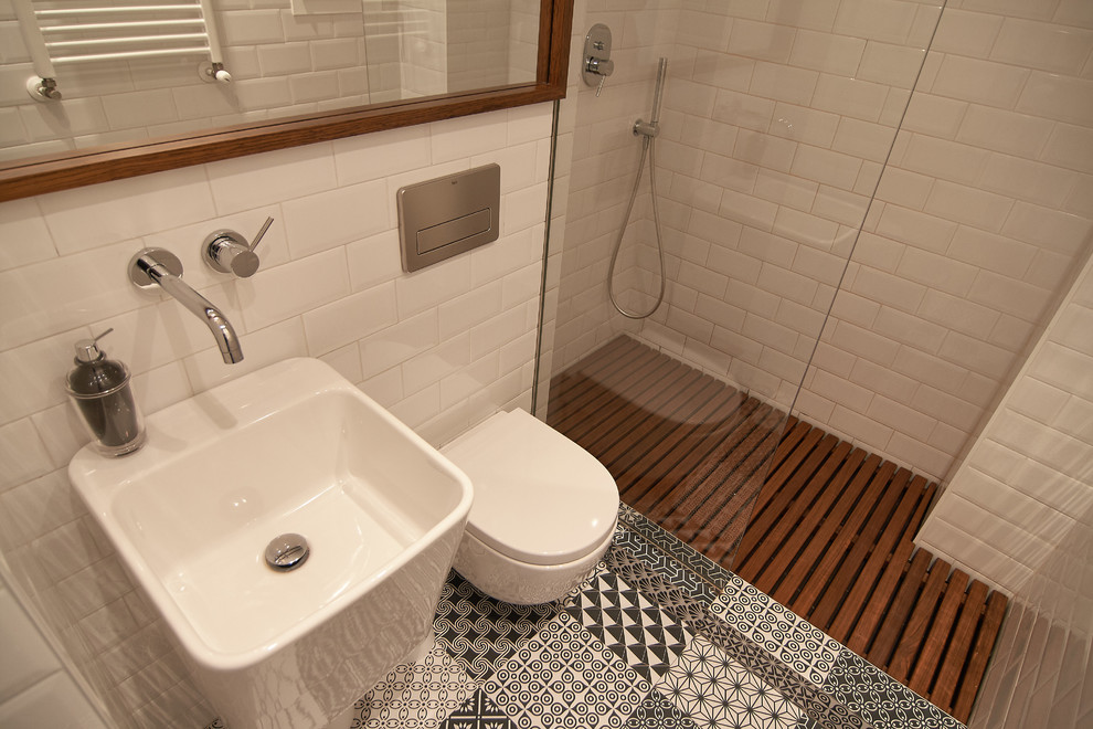 Design ideas for a small contemporary 3/4 bathroom in Bilbao with an alcove shower, a wall-mount toilet, white tile, subway tile, white walls, ceramic floors and a wall-mount sink.