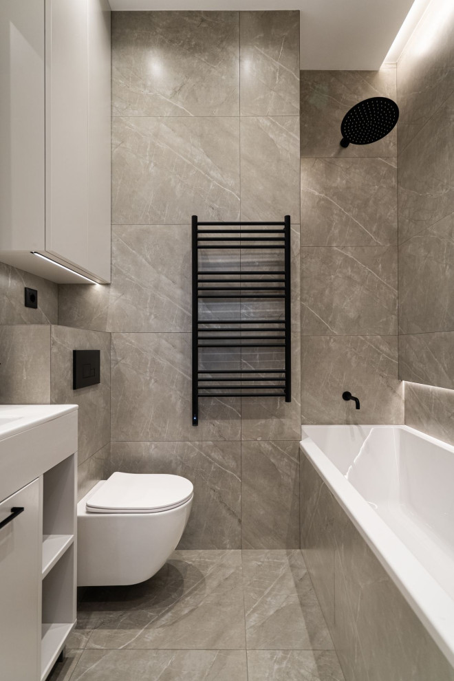 Photo of a mid-sized contemporary master bathroom in Other with flat-panel cabinets, grey cabinets, an alcove tub, a wall-mount toilet, gray tile, porcelain tile, grey walls, ceramic floors, an undermount sink, solid surface benchtops, grey floor, white benchtops and a single vanity.