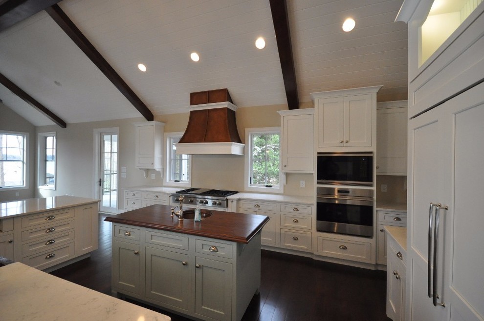 Large minimalist u-shaped dark wood floor eat-in kitchen photo with a drop-in sink, recessed-panel cabinets, white cabinets, granite countertops, stainless steel appliances and an island