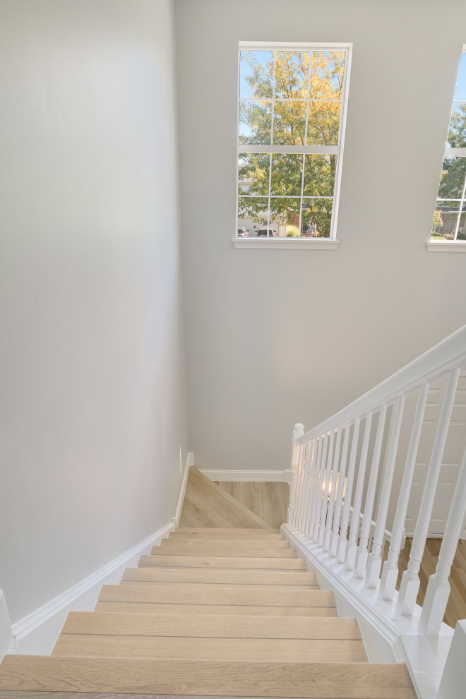 This is an example of a medium sized traditional wood l-shaped wood railing staircase in Chicago with concrete risers.