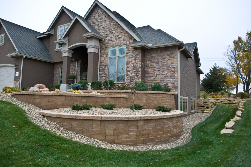 Photo of a large traditional front yard garden in Other with a retaining wall.
