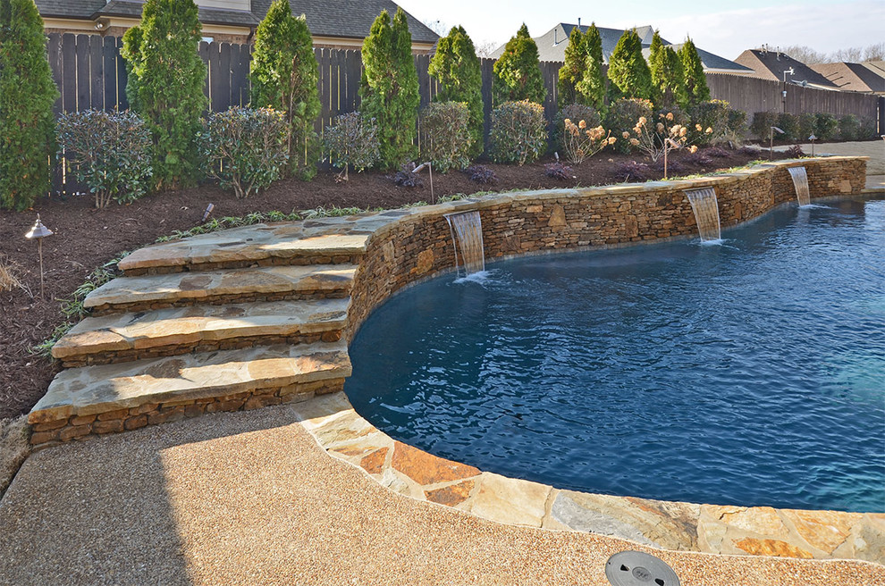 Example of a large island style backyard concrete and custom-shaped lap pool fountain design