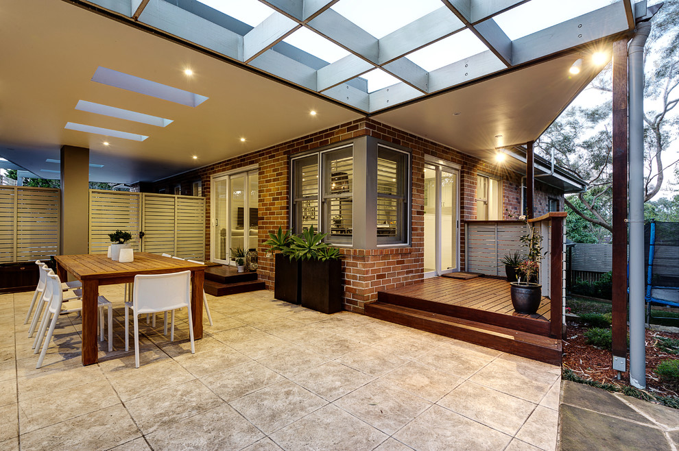 Inspiration for a large contemporary backyard patio in Sydney with tile and a roof extension.