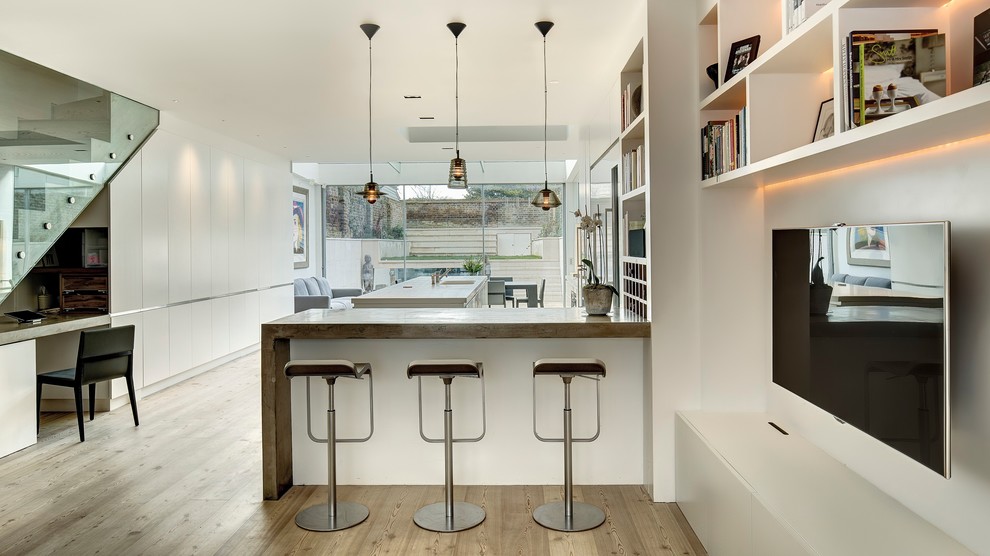 Photo of an expansive contemporary l-shaped open plan kitchen in London with flat-panel cabinets, white cabinets and with island.