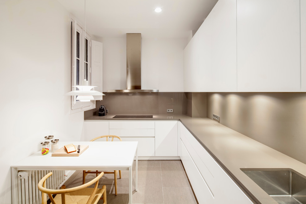 Inspiration for a mid-sized contemporary l-shaped eat-in kitchen in Barcelona with a single-bowl sink, flat-panel cabinets, white cabinets, ceramic floors and no island.