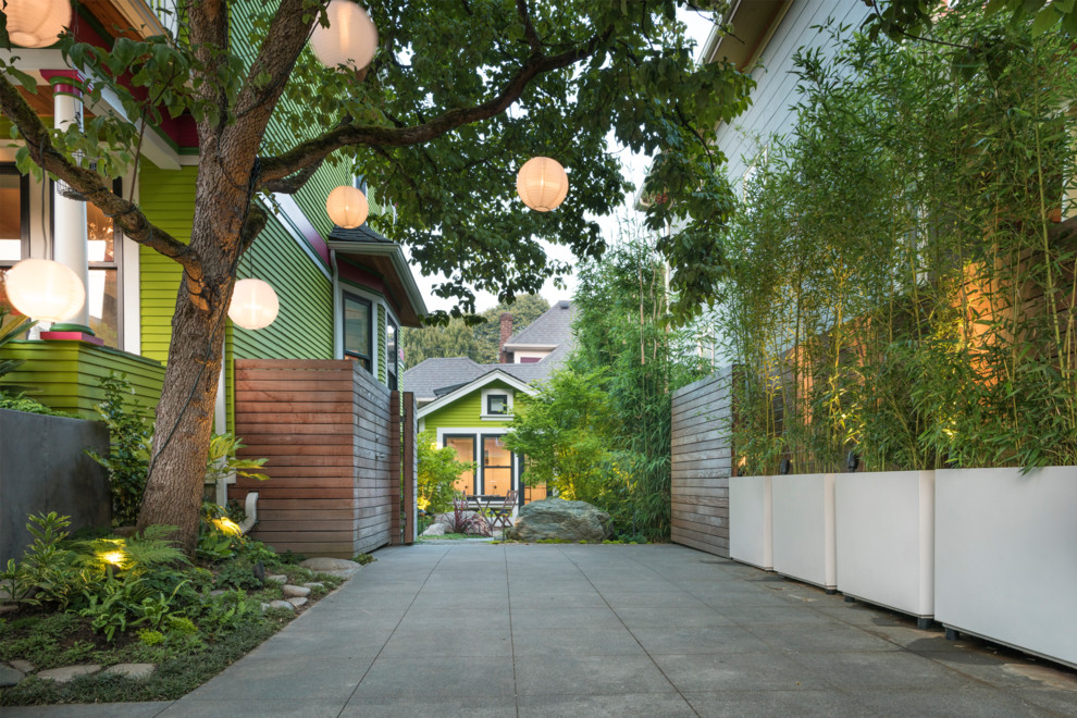 Design ideas for a mid-sized contemporary front yard partial sun driveway in Seattle with a container garden and concrete pavers.