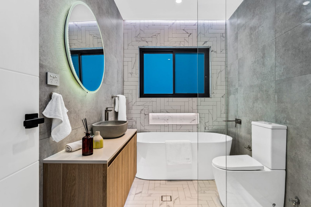 Inspiration for a contemporary bathroom in Sydney with flat-panel cabinets, medium wood cabinets, a freestanding tub, a two-piece toilet, gray tile, a vessel sink, white floor, grey benchtops, a niche, a single vanity and a floating vanity.