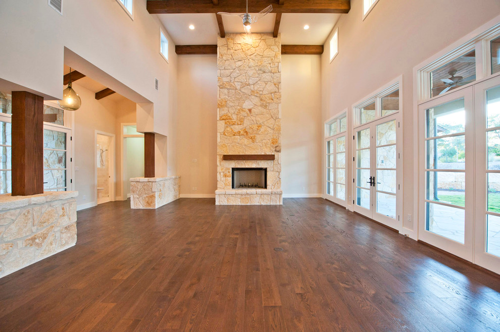 Photo of a large contemporary open concept living room in Austin with beige walls, medium hardwood floors, a standard fireplace and a stone fireplace surround.