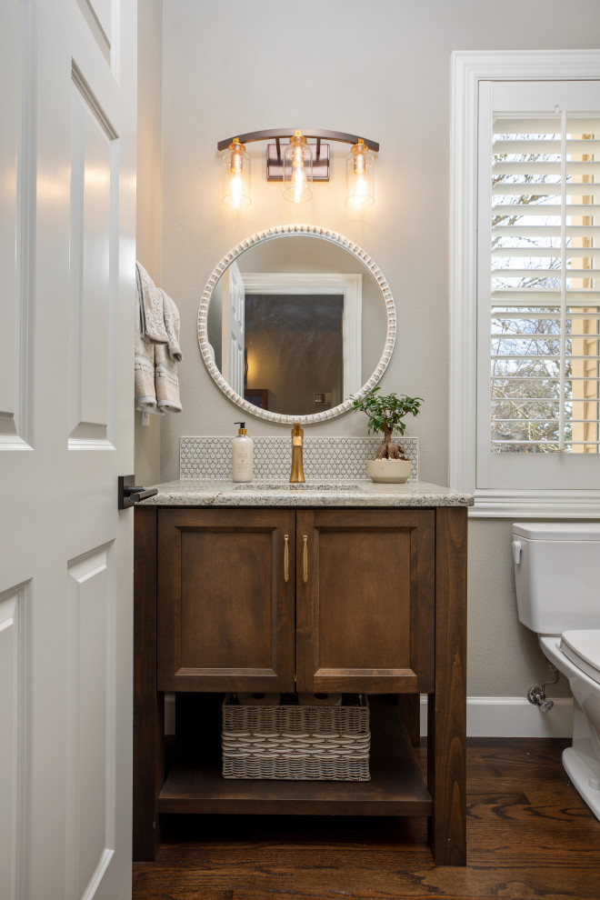 Photo of a small transitional 3/4 bathroom in Portland with recessed-panel cabinets, medium wood cabinets, a two-piece toilet, gray tile, grey walls, dark hardwood floors, an undermount sink, granite benchtops, brown floor, grey benchtops, a single vanity and a freestanding vanity.