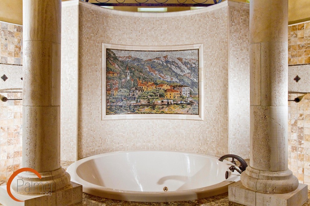 This is an example of a traditional bathroom in Austin with a drop-in tub, beige tile and mosaic tile.