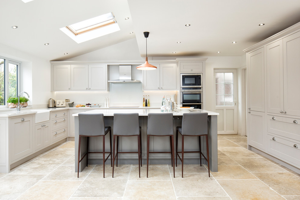 Inspiration for a traditional kitchen in Berkshire with a farmhouse sink, recessed-panel cabinets, grey cabinets, white splashback, stainless steel appliances and with island.