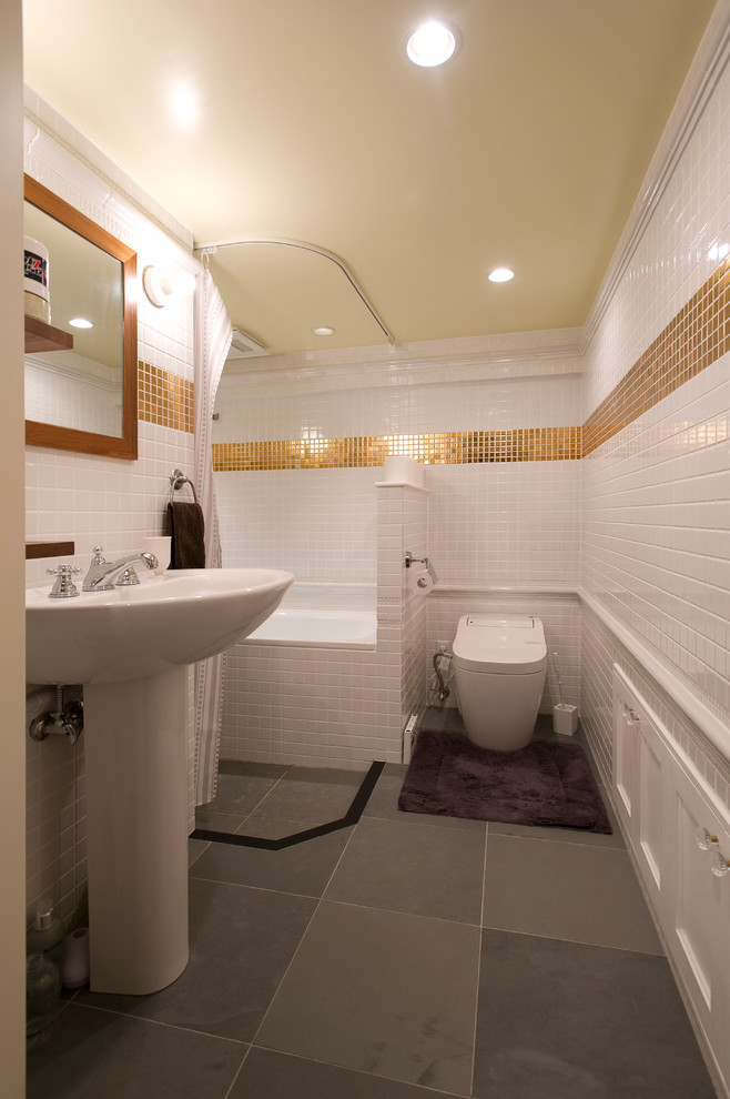 Drop-in bathtub - master white tile and glass tile slate floor drop-in bathtub idea in Tokyo with a one-piece toilet, white walls and a pedestal sink