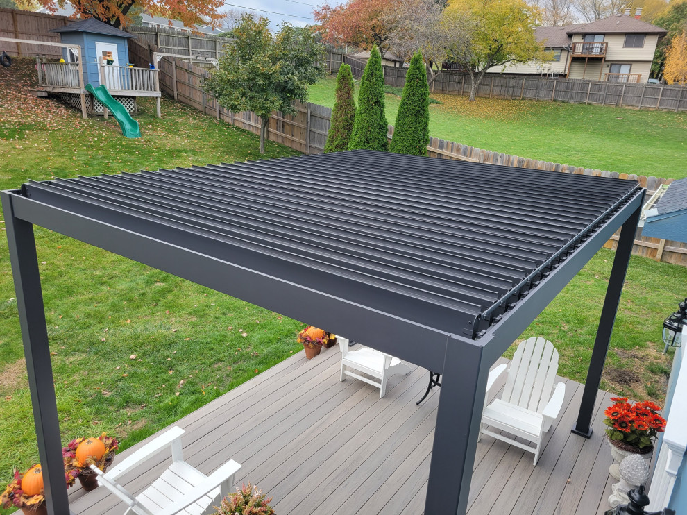 Photo of a large back ground level metal railing terrace in Other with a pergola.