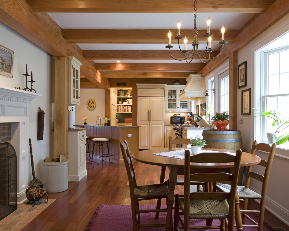 This is an example of a country dining room in Bridgeport with white walls, medium hardwood floors and a standard fireplace.